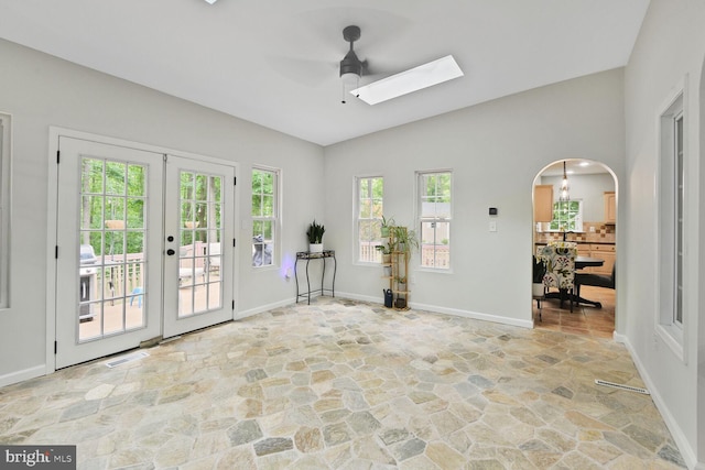 310 Owings Hill Ct, Owings, MD 20736 - spare room featuring stone floors, ceiling fan, a skylight, vaulted ceiling, and arched walkways