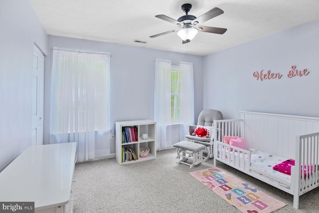 310 Owings Hill Ct, Owings, MD 20736 - bedroom with carpet floors, a nursery area, a ceiling fan, and a textured ceiling