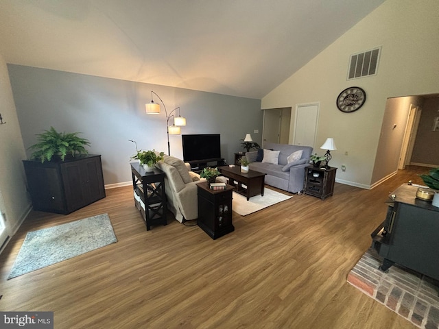 21 Moby Dick Dr, Ocean Pines, MD 21811 - living area featuring wood finished floors, a wood stove, baseboards, and high vaulted ceiling