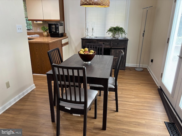 21 Moby Dick Dr, Ocean Pines, MD 21811 - dining room featuring baseboards, light wood-style floors, and a baseboard radiator