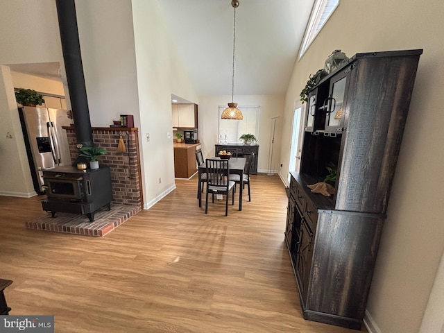 21 Moby Dick Dr, Ocean Pines, MD 21811 - dining space featuring light wood-type flooring, baseboards, high vaulted ceiling, and a wood stove