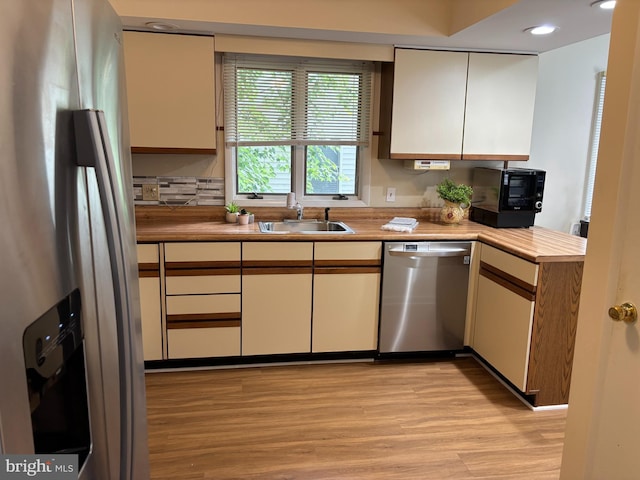 21 Moby Dick Dr, Ocean Pines, MD 21811 - kitchen featuring appliances with stainless steel finishes, a sink, light wood finished floors, a peninsula, and light countertops