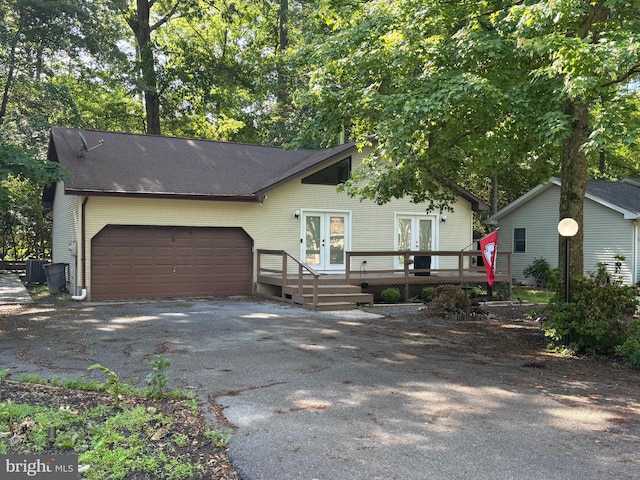 21 Moby Dick Dr, Ocean Pines, MD 21811 - view of front of home with french doors, driveway, an attached garage, a wooden deck, and central air condition unit