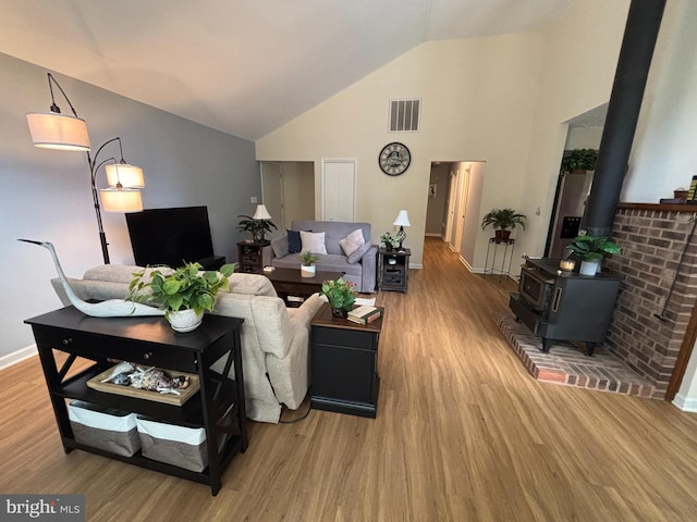 21 Moby Dick Dr, Ocean Pines, MD 21811 - living area with light wood-style floors, high vaulted ceiling, a wood stove, and baseboards