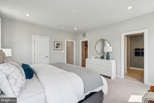 bedroom featuring light colored carpet, a spacious closet, recessed lighting, baseboards, and a closet