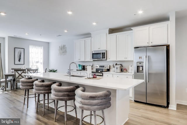 613 Percy Pl # B, Manassas Park, VA 20111 - kitchen with stainless steel appliances, a sink, light wood-type flooring, an island with sink, and recessed lighting