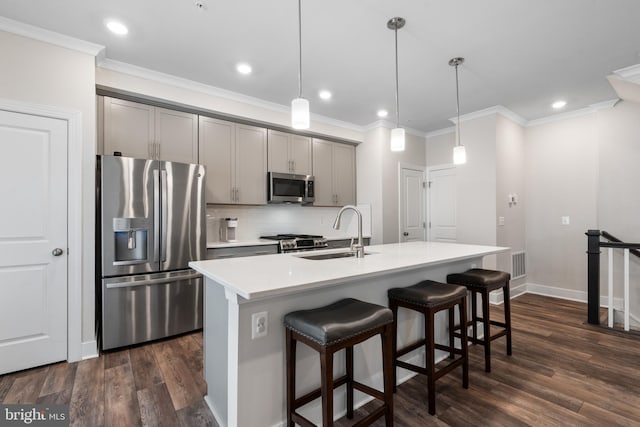 15590 Grade Line Pl, Woodbridge, VA 22191 - kitchen featuring appliances with stainless steel finishes, gray cabinets, a sink, decorative backsplash, and a kitchen bar