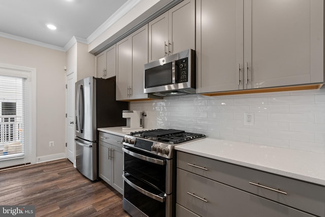 15590 Grade Line Pl, Woodbridge, VA 22191 - kitchen with appliances with stainless steel finishes, gray cabinetry, ornamental molding, dark wood-style flooring, and backsplash