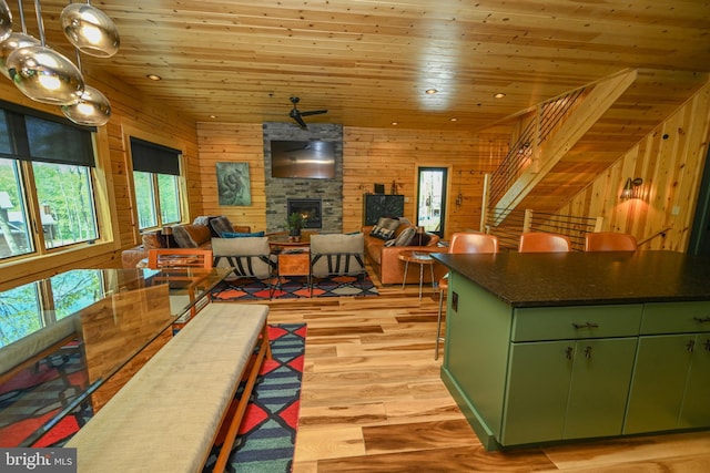 1067 N Camp Rd, Mc Henry, MD 21541 - kitchen featuring green cabinetry, wood ceiling, light wood finished floors, a fireplace, and wood walls