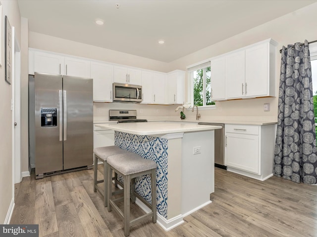 5809 Zoe Ln, Frederick, MD 21704 - kitchen with appliances with stainless steel finishes, a center island, white cabinets, light wood-style flooring, and recessed lighting