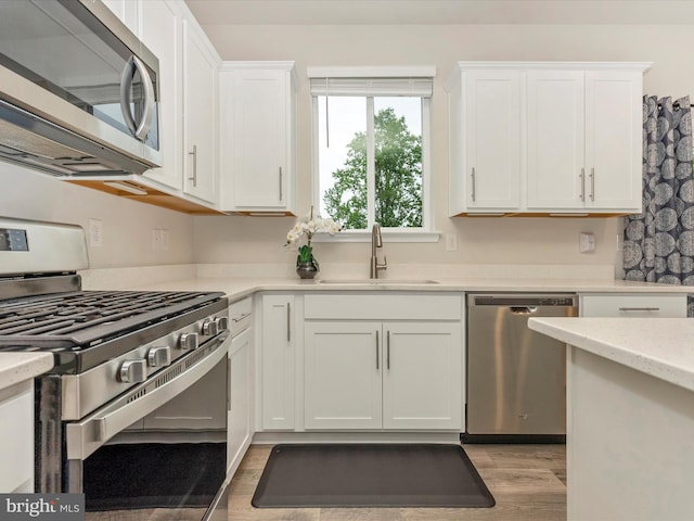 5809 Zoe Ln, Frederick, MD 21704 - kitchen featuring stainless steel appliances, a sink, white cabinets, and light wood finished floors