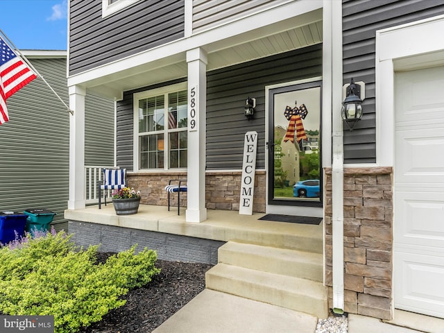 5809 Zoe Ln, Frederick, MD 21704 - doorway to property featuring stone siding, a porch, and a garage
