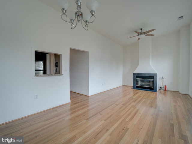 1812 Vernon St NW Unit 42, Washington, DC 20009 - unfurnished living room featuring wood finished floors, a ceiling fan, a chandelier, a fireplace with flush hearth, and vaulted ceiling