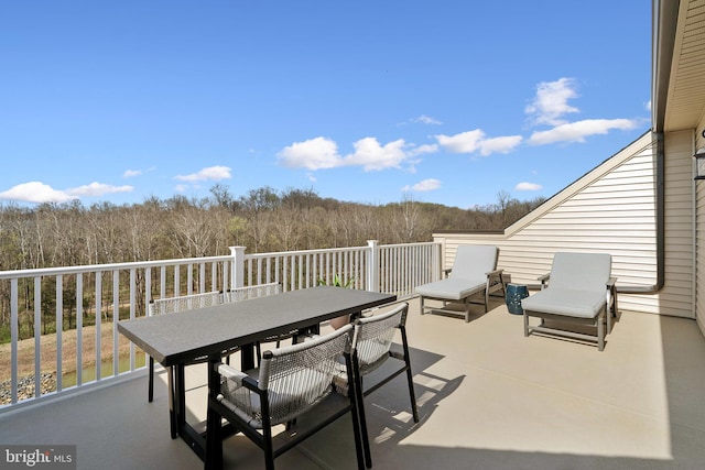 view of patio / terrace with a view of trees and outdoor dining space