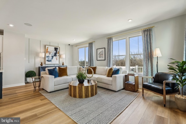 living area with light wood-type flooring, recessed lighting, and baseboards