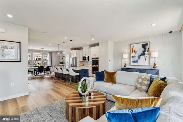 living area featuring light wood-style floors, recessed lighting, and baseboards
