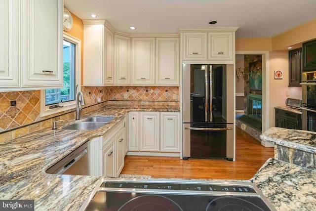 3097 Mill Rd, Doylestown, PA 18902 - kitchen featuring appliances with stainless steel finishes, a sink, light wood-style floors, light stone countertops, and backsplash