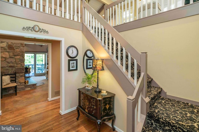 3097 Mill Rd, Doylestown, PA 18902 - stairway featuring wood finished floors, baseboards, a towering ceiling, and a fireplace