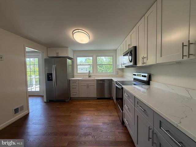 4205 Middle Ridge Dr, Fairfax, VA 22033 - kitchen with appliances with stainless steel finishes, a sink, dark wood finished floors, light stone countertops, and gray cabinetry