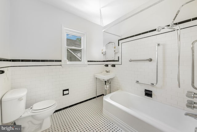 full bathroom featuring tile walls, toilet, wainscoting, and tile patterned floors