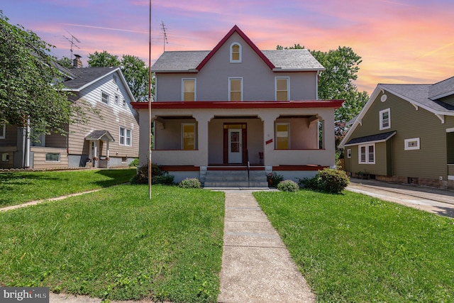 view of front of home with stucco siding, a porch, and a front lawn