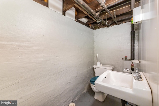bathroom featuring a sink, toilet, and concrete floors
