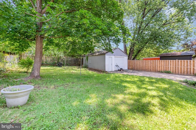 view of yard with a detached garage and a patio area