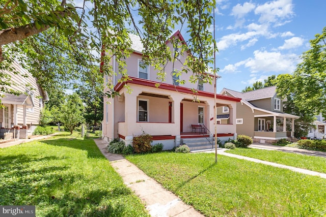 view of front facade with covered porch, a front yard, and stucco siding