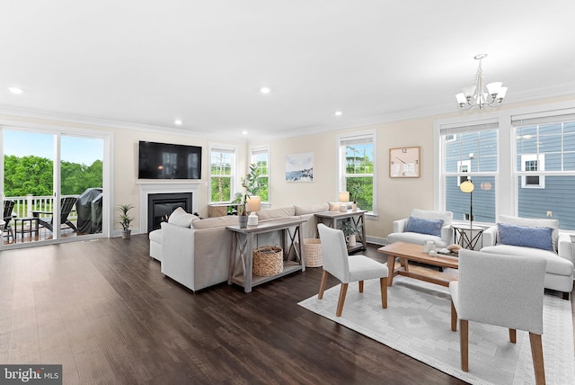 19253 Running Spring Ct, Leesburg, VA 20175 - living room with crown molding, dark wood-type flooring, plenty of natural light, a chandelier, and a glass covered fireplace