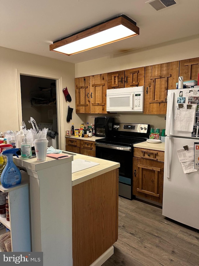 801 Christopher Dr, Reading, PA 19610 - kitchen featuring white appliances, brown cabinets, wood finished floors, and light countertops
