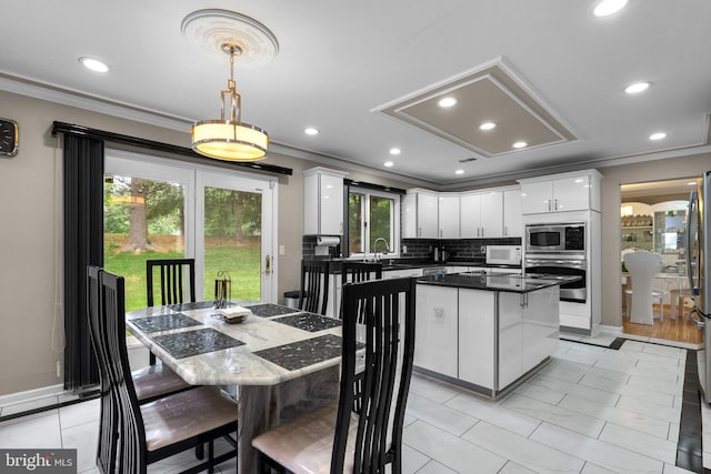20008 Giantstep Ter, Gaithersburg, MD 20886 - kitchen with stainless steel appliances, crown molding, white cabinetry, dark countertops, and a center island