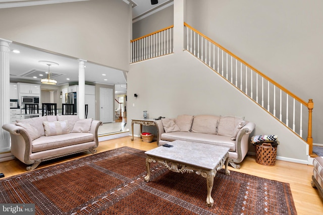20008 Giantstep Ter, Gaithersburg, MD 20886 - living area featuring ornate columns, light wood-type flooring, stairway, a high ceiling, and baseboards