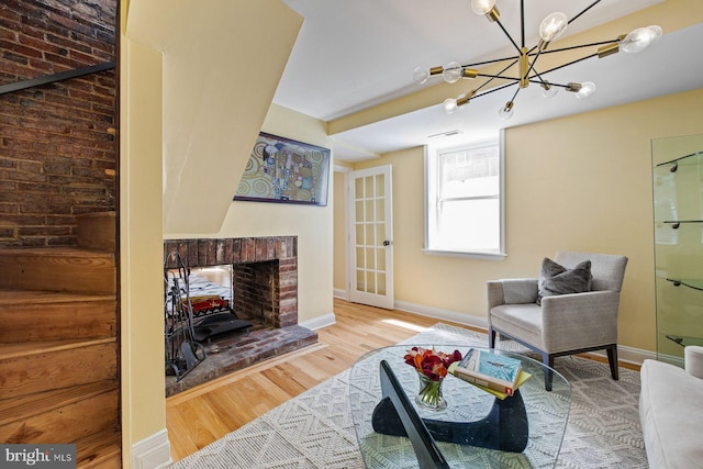 826 S 2nd St Unit 2, Philadelphia, PA 19147 - living room featuring wood finished floors, a chandelier, baseboards, and a brick fireplace
