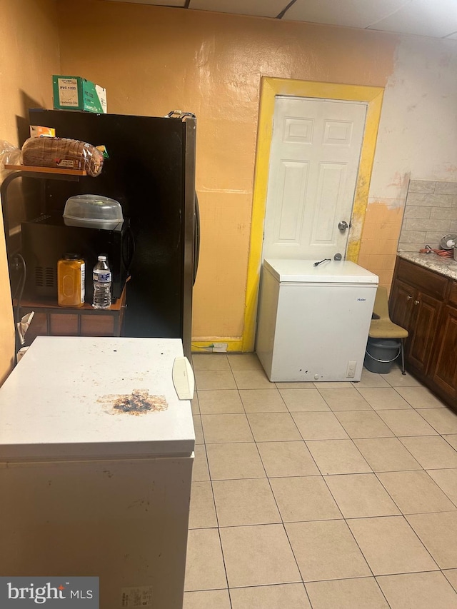 5823 Filbert St, Philadelphia, PA 19139 - kitchen featuring light tile patterned floors, light countertops, freestanding refrigerator, and fridge