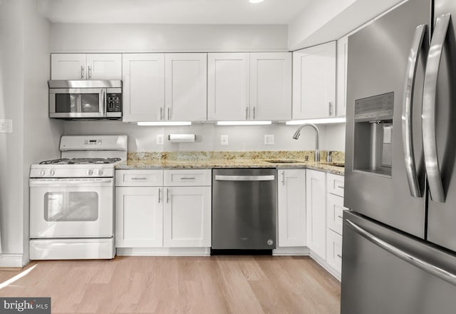7374 Park Heights Ave, Baltimore, MD 21208 - kitchen featuring stainless steel appliances, a sink, white cabinets, and light wood-type flooring