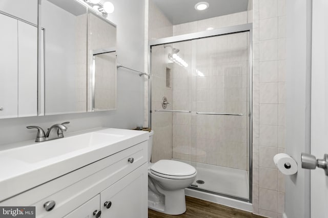 7374 Park Heights Ave, Baltimore, MD 21208 - bathroom featuring a stall shower, wood finished floors, toilet, and vanity