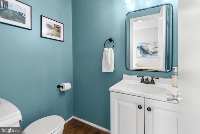 7374 Park Heights Ave, Baltimore, MD 21208 - bathroom featuring toilet, wood finished floors, baseboards, and vanity