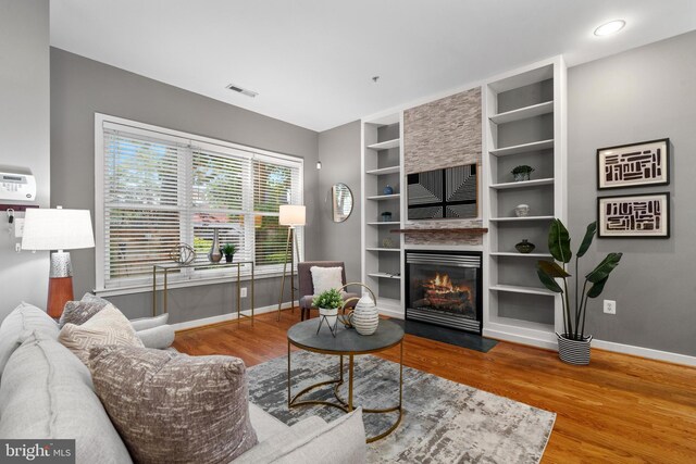 1423 1st St NW Unit B, Washington, DC 20001 - living room featuring wood finished floors, baseboards, a fireplace with flush hearth, and built in features