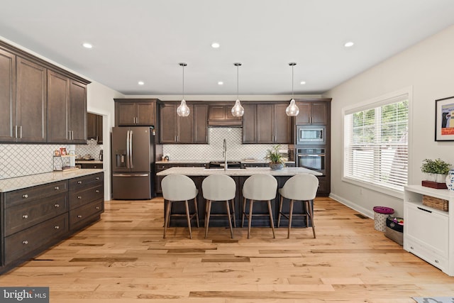 1413 Cortez Rd, Blue Bell, PA 19422 - kitchen featuring stainless steel appliances, dark brown cabinetry, tasteful backsplash, a breakfast bar area, and recessed lighting