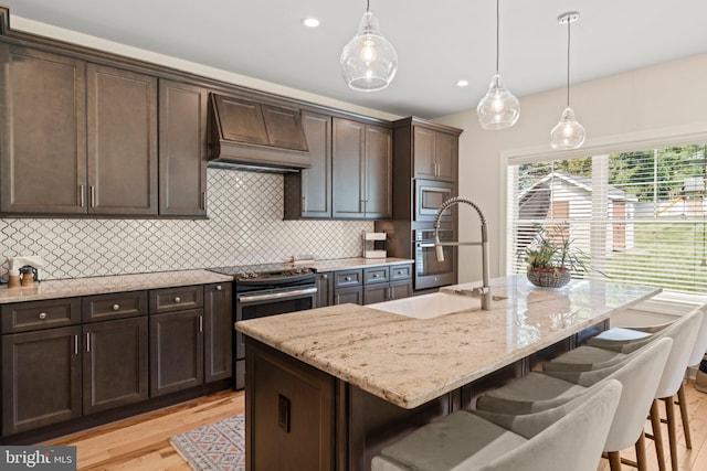 1413 Cortez Rd, Blue Bell, PA 19422 - kitchen with premium range hood, stainless steel appliances, a sink, light wood-type flooring, and dark brown cabinets