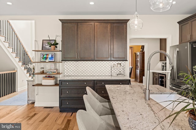 1413 Cortez Rd, Blue Bell, PA 19422 - kitchen featuring dark brown cabinets, open shelves, decorative backsplash, stainless steel fridge, and light wood-type flooring
