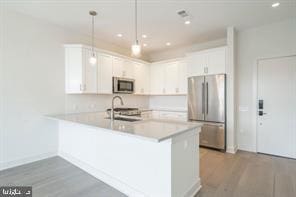 575 S Goddard Blvd Unit 511, King Of Prussia, PA 19406 - kitchen with appliances with stainless steel finishes, a sink, light countertops, a peninsula, and white cabinets