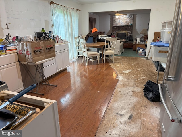 801 Irenic Ct, Norristown, PA 19403 - kitchen featuring hardwood / wood-style floors, white cabinetry, a stone fireplace, and freestanding refrigerator