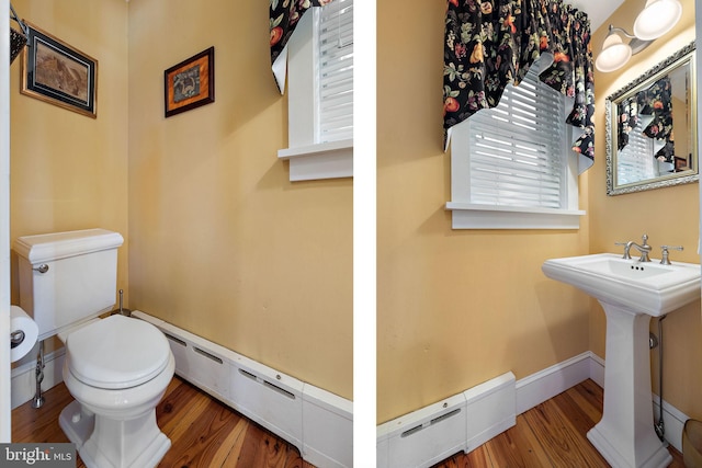 55 The Strand, New Castle, DE 19720 - bathroom featuring toilet, a baseboard heating unit, wood finished floors, and a sink