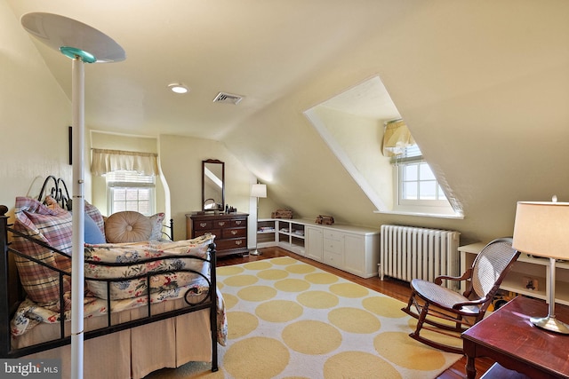 55 The Strand, New Castle, DE 19720 - bedroom with radiator, vaulted ceiling, multiple windows, and wood finished floors
