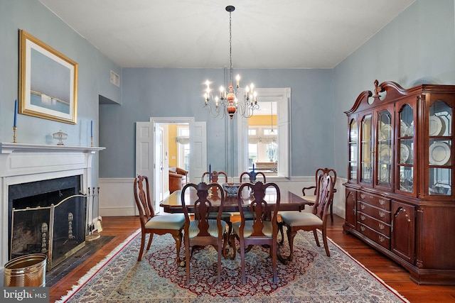 55 The Strand, New Castle, DE 19720 - dining area featuring dark wood finished floors, a chandelier, wainscoting, and a fireplace with flush hearth