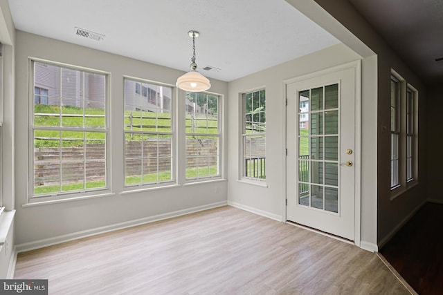 unfurnished sunroom with wood finished floors and baseboards