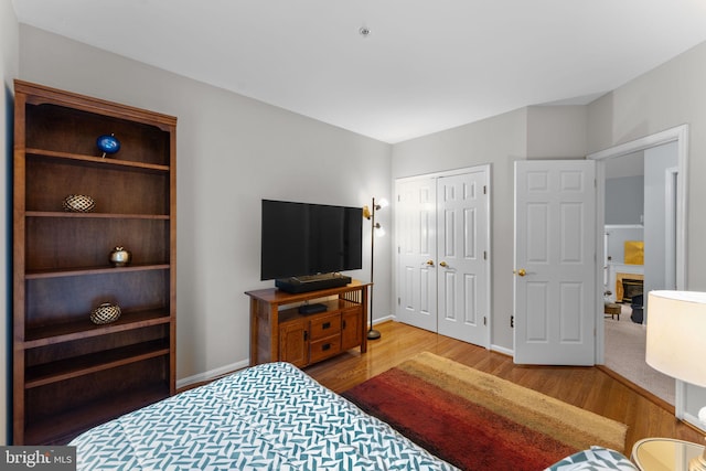 4669 Lawton Way Unit 104, Alexandria, VA 22311 - bedroom with wood finished floors, a closet, baseboards, and a glass covered fireplace