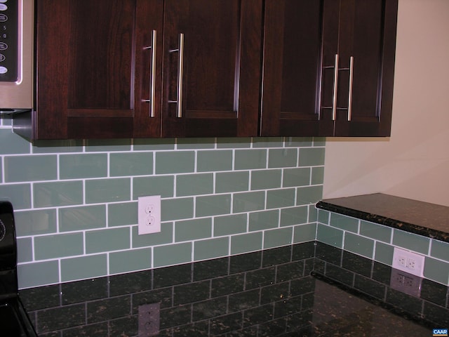 101 Sterling Dr, Waynesboro, VA 22980 - kitchen view of stainless steel microwave, dark brown cabinetry, dark stone countertops, and tasteful backsplash