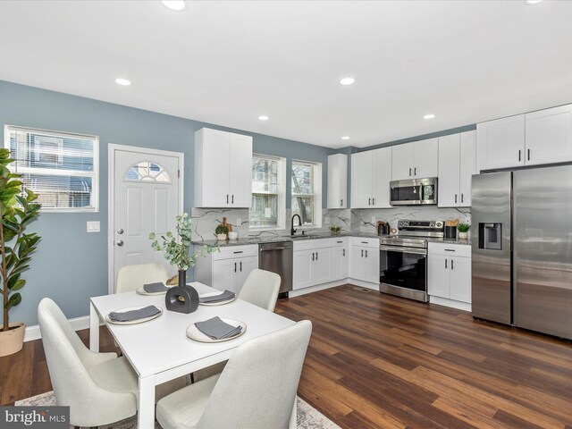5443 Jonquil Ave, Baltimore, MD 21215 - kitchen featuring appliances with stainless steel finishes, backsplash, dark wood finished floors, white cabinetry, and recessed lighting